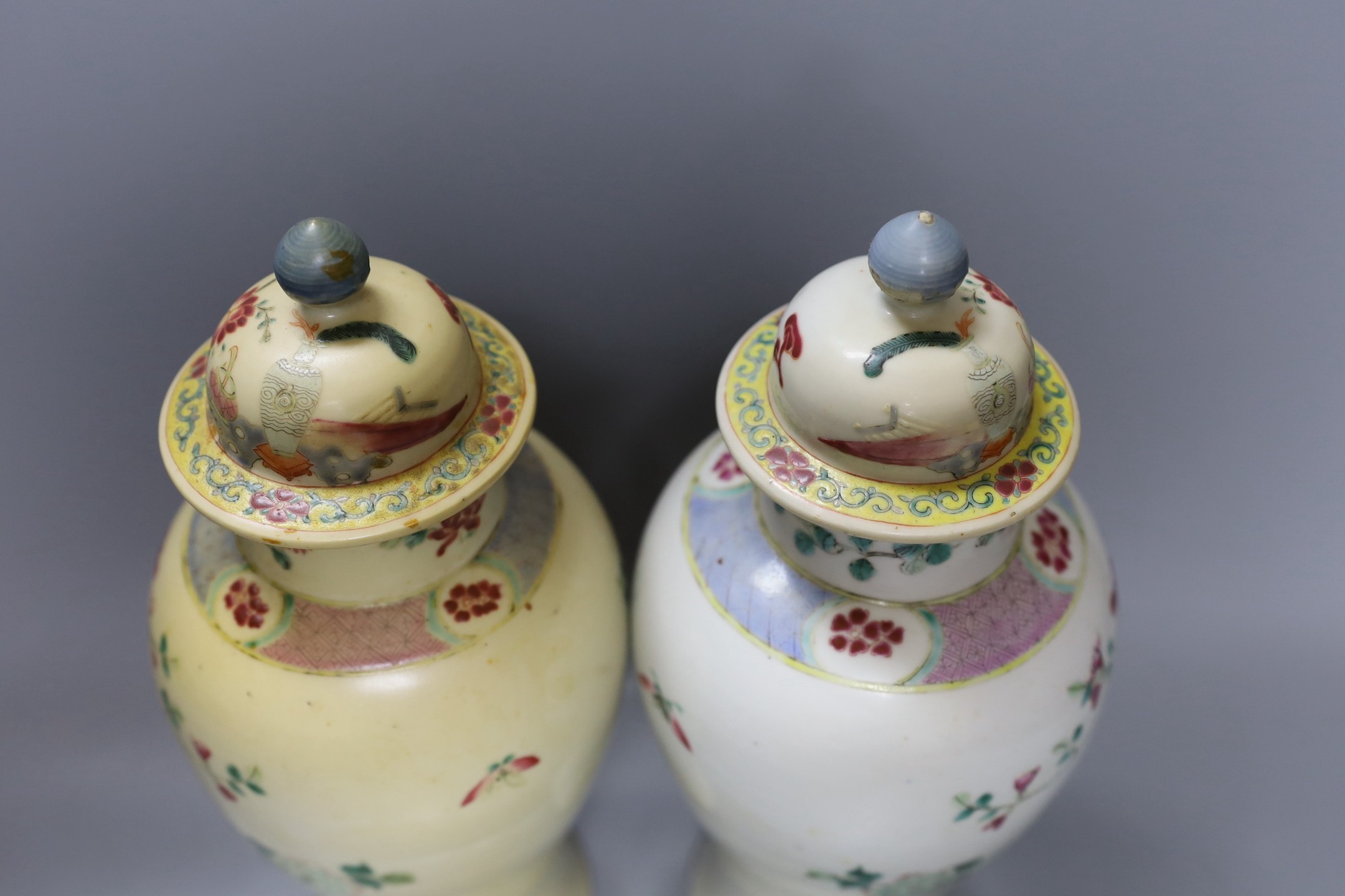 A pair of 19th century Chinese famille rose vases and covers - 27cm tall